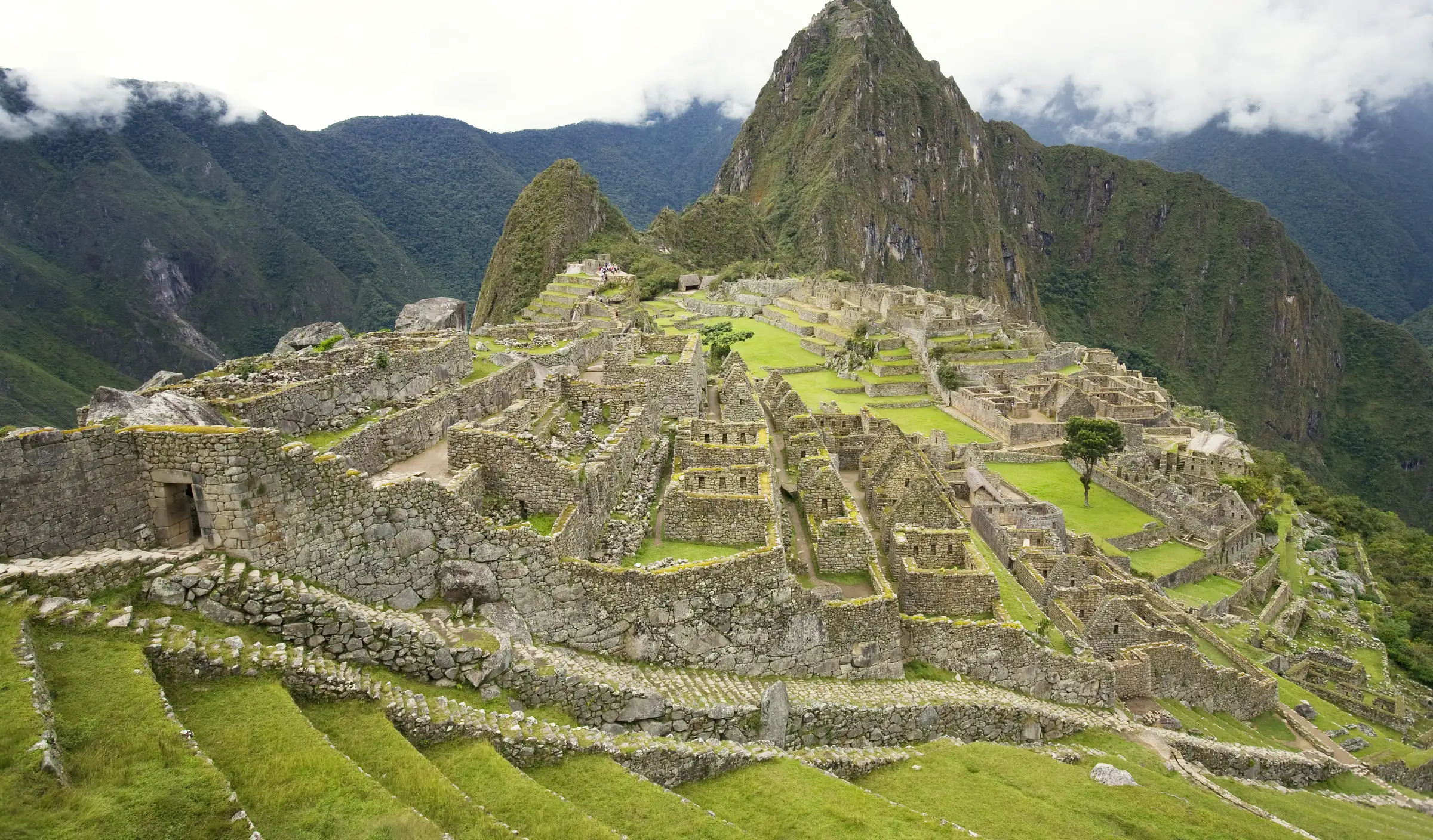 Machu Picchu citadel in bright green morning light with Huayna Picchu rising behind it